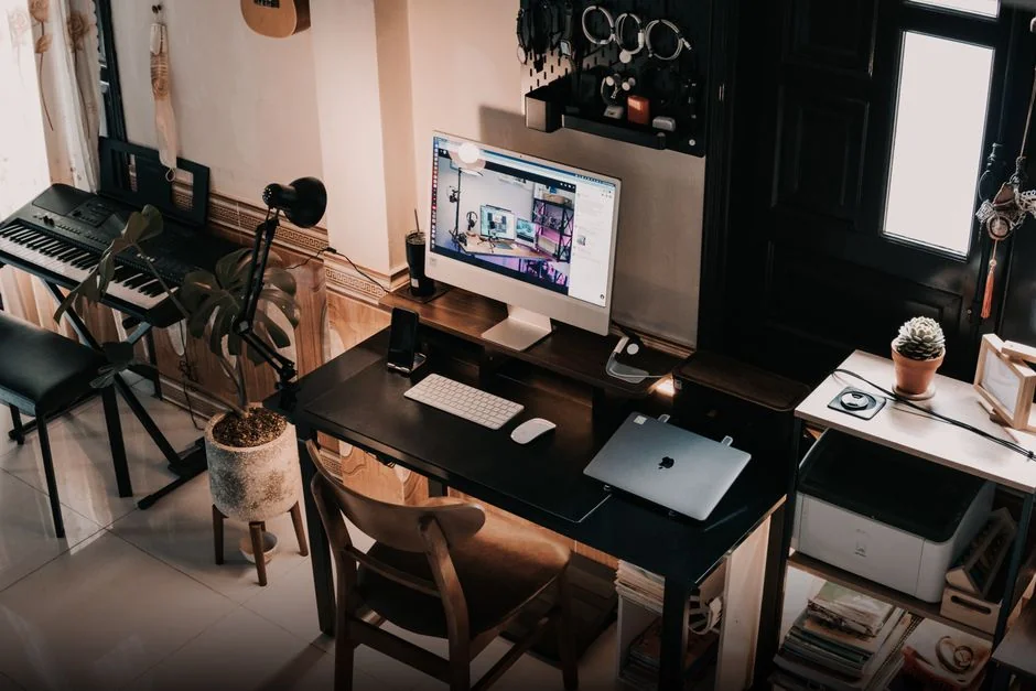Man working on web design at home office setup with dual monitors.
