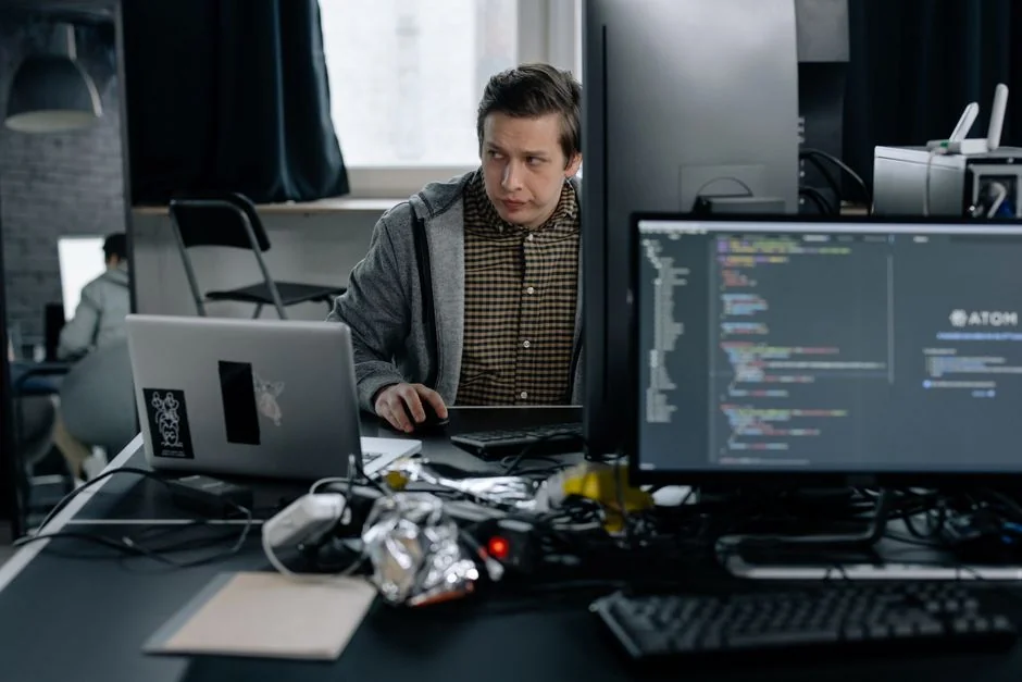 Stylish and efficient workspace with multiple monitors, laptop, and smartphone, showcasing a web design project.